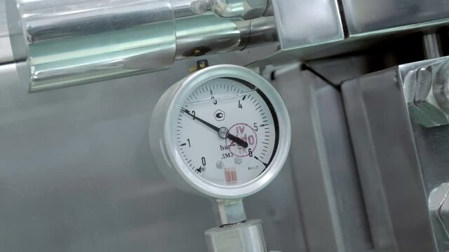 Pressure gauge on industrial equipment, compressors, water pipelines, gas pipelines, tanks, measures the pressure of a liquid or gas in a system. Shot in motion. Closeup