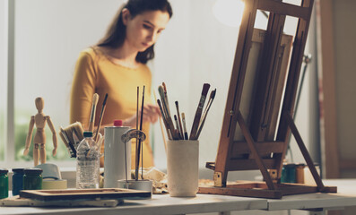 Creative woman painting on canvas in the studio