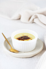 Vegan creme brulee in a bowl on a light table. Sugar, gluten and lactose free.