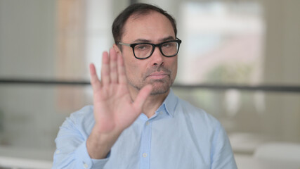 Middle Aged Man Showing Stop Sign by Hand
