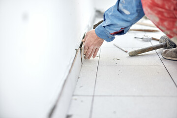 Ceramics tile man worker placing new tiles on the floor and wall.