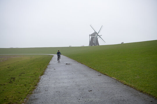 Fahrradtour auf dem Deich. Im Hintergrund die Norderm&uuml;hle, Insel Pellworm