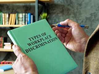 Manager holds book types of workplace discrimination.