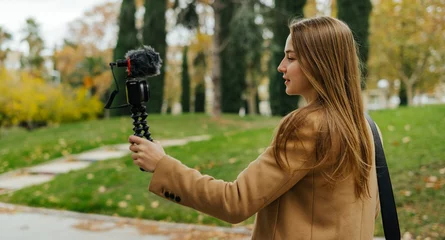 Fototapeten Young stylish woman taking video for vlog. Female vlogger influencer creating social media content © Rymden