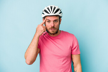 Young caucasian man with bike helmet isolated on blue background showing a disappointment gesture with forefinger.