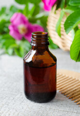 Small bottle with essential oil (extract, infusion, tincture) on the old wooden background. Aromatherapy, spa and herbal medicine ingredients. Copy space.