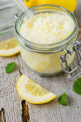 Homemade sea salt and lemon fruit scrub (bath salt, foot soak) in a glass jar. Natural beauty treatment and spa recipe.