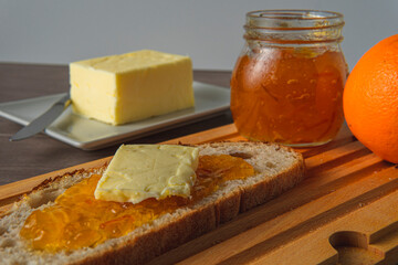 breakfast consisting of rustic bread, orange marmalade and butter