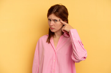 Young English woman isolated on yellow background pointing temple with finger, thinking, focused on a task.