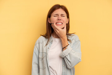 Young English woman isolated on yellow background having a strong teeth pain, molar ache.