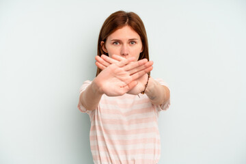Young English woman isolated on blue background doing a denial gesture