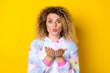 Portrait of attractive amazed girly wavy-haired girl in pajama sending air kiss isolated over...