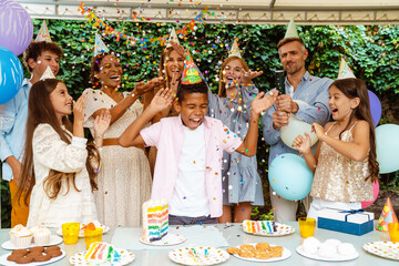 Black boy celebrating birthday with her parents and friends