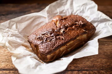 Baked banana bread. Dark wooden background. A whole freshly made loaf of bread.