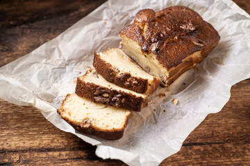 Baked banana bread. Cut into pieces. Dark wooden background. Bread with walnuts.