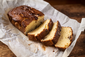 Baked banana bread. Cut into pieces. Dark wooden background. Bread with walnuts.
