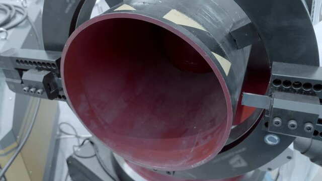 Industrial equipment for high-quality automatic cutting of metal pipes of large diameter by circular movement of the cutter - without scale and burrs. Shot in motion. Closeup