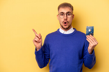 Young computer man isolated on yellow background pointing to the side