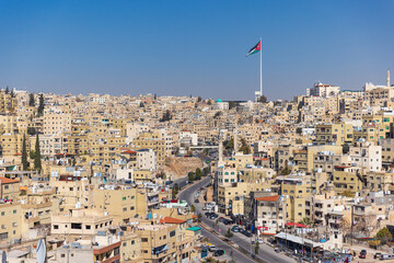 Jordan flag in Amman, cityscape view