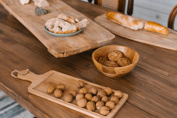 Walnuts on a wooden cutting board in a wooden plate in the kitchen