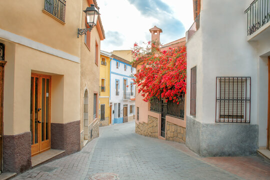 Small towns of Spain. A street in the picturesque town of Polop in the province of Alicante, not far from the famous resort of Benidorm. Travel and vacation concept. Blue sky in the background.