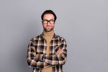 Photo of positive dreamy guy dressed checkered shirt glasses arms folded empty space isolated grey color background