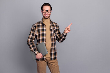 Photo of positive guy dressed checkered shirt glasses holding device empty space isolated grey color background