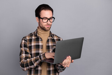 Photo of sweet confident guy dressed checkered shirt glasses typing modern device isolated grey color background