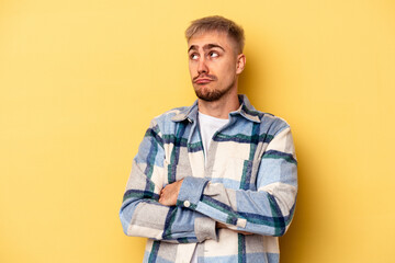 Young caucasian man isolated on yellow background dreaming of achieving goals and purposes