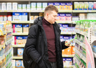 Man in the children's grocery section chooses baby food.