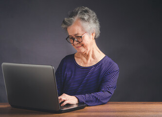An elderly Asian woman using a laptop for searching data on the internet