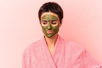 Young caucasian woman wearing a face mask isolated on pink background confused, feels doubtful and unsure.