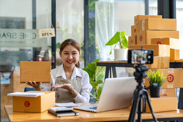Startup small business SME. Beautiful asian entrepreneur using camera live streaming online chat with her customer. Successful SME business online concept..