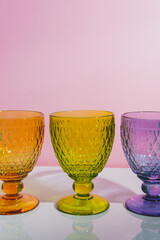 Three stylish colorful faceted glasses with shadows in pink and white corner. Minimalism - 479564173