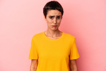 Young caucasian woman isolated on blue background blows cheeks, has tired expression. Facial...