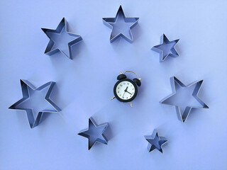The concept of sleep. Night sky with purple background, stars and alarm clock