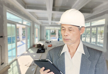 senior Asian construction architect inspecting the workplace.