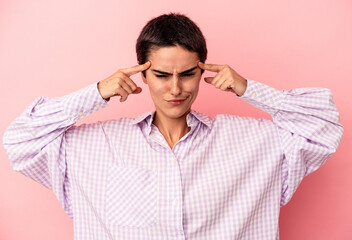 Young caucasian woman isolated on blue background focused on a task, keeping forefingers pointing head.