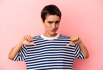 Young caucasian woman isolated on blue background showing thumb down, disappointment concept.