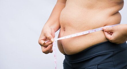 Fat woman holding excessive belly fat with measuring tape. Healthcare and woman diet lifestyle concept to reduce belly and shape up healthy stomach muscle.