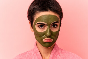 Young caucasian woman wearing a face mask isolated on pink background