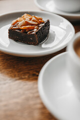 Brownie with almonds on a wooden table in a cafe.