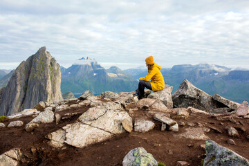 Happy family, standing on a rock and looking over Segla mountain on Senja island, North Norway....