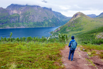 Happy family, standing on a rock and looking over Segla mountain on Senja island, North Norway. Amazing beautiful landscape and splendid nature