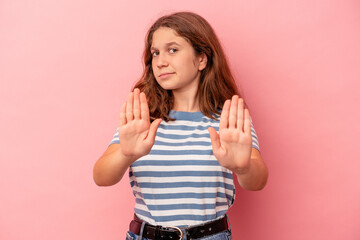 Little caucasian girl isolated on pink background standing with outstretched hand showing stop sign, preventing you.