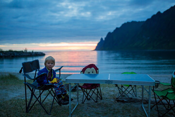 Children, enjoying sunset on Ersfjord Beach on Senja island, beautiful landscape view over the mountains