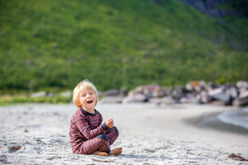Cute toddler child, eating vitamin pills for children on the beach, child taking additional...