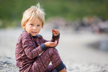 Cute toddler child, eating vitamin pills for children on the beach, child taking additional...