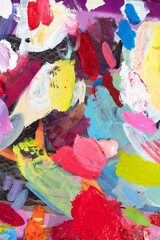 An artist's palette with multi-colored strokes of oil paint.