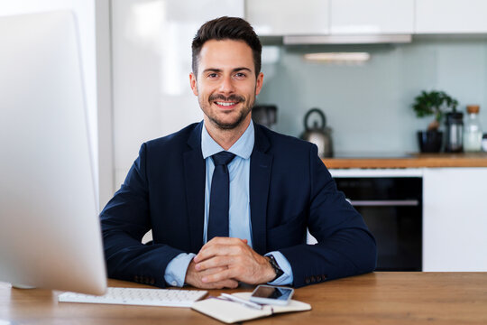 Portrait of smiling businessman in suit working from home